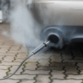 Car exhaust with visible fumes and test equipment attached