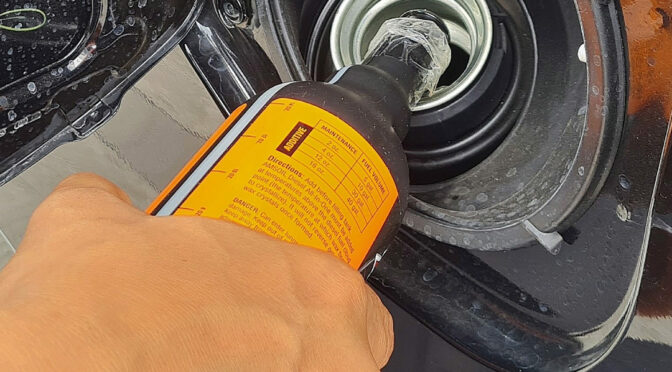Fuel additive being added to a vehicles fuel tank.